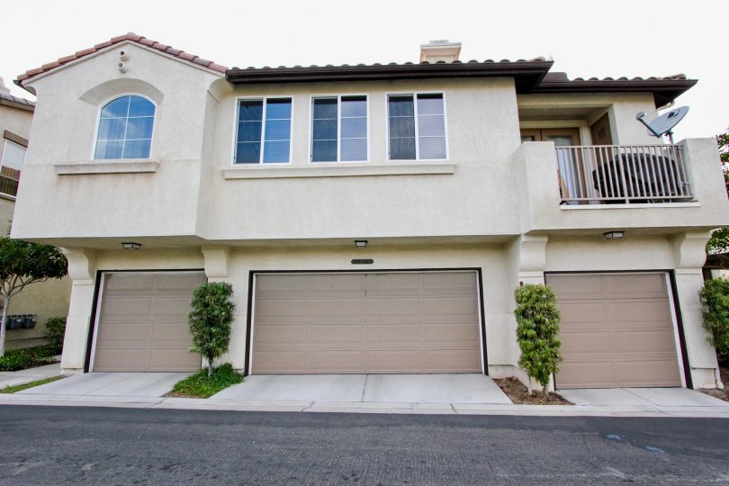 Street view of above-garage apartments with satellite television and grille on upper deck: Chula Vista, CA