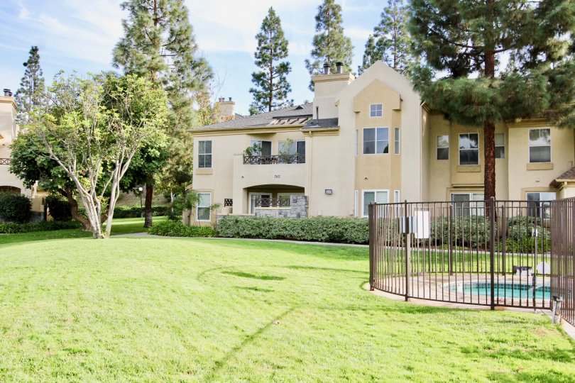 Large green field around a swimming pool with a fence at Camelot in Chula Vista CA