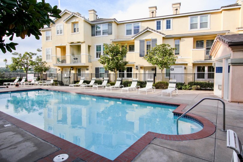 A still pool reflects a pale yellow building at Graystone condos