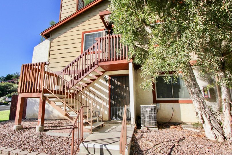 A large tree hangs over a staircase leading into a home in Hilltop Village, in the city of Chula Vista, CA.