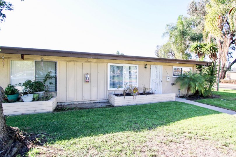 Clean and clear front yard have trees and plants in front of the garage in Karen Condominiums