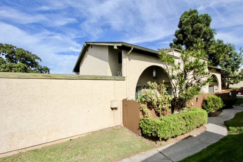 A bungalow with green roofing in the Melrose Place Townhomes community on a sunny day.