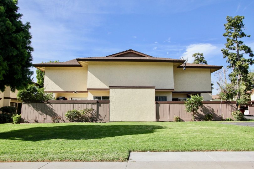 A house with lawn infront of the open area and with trees