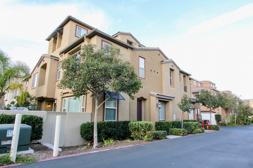 A home located in Veranza community in Chula Vista, California. This is a large home with trees and other foliage, showing the street it is located on.