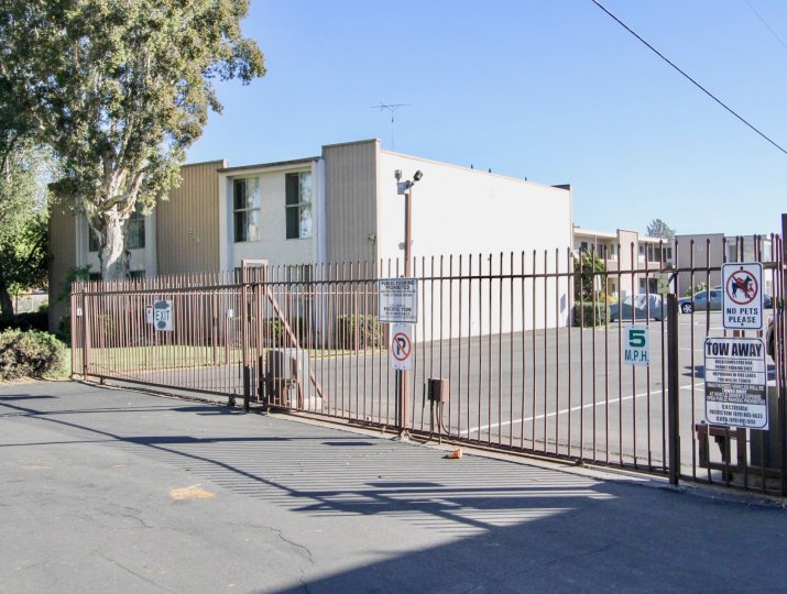 Compound entrance gate with No parking and No pets sign in front of the buildings in Villa Campestre