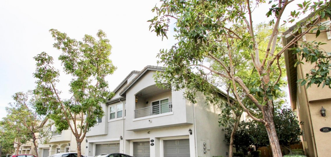 The exterior of a few willow bend homes showing balconies and garage entrances as well as trees in Chula Vista