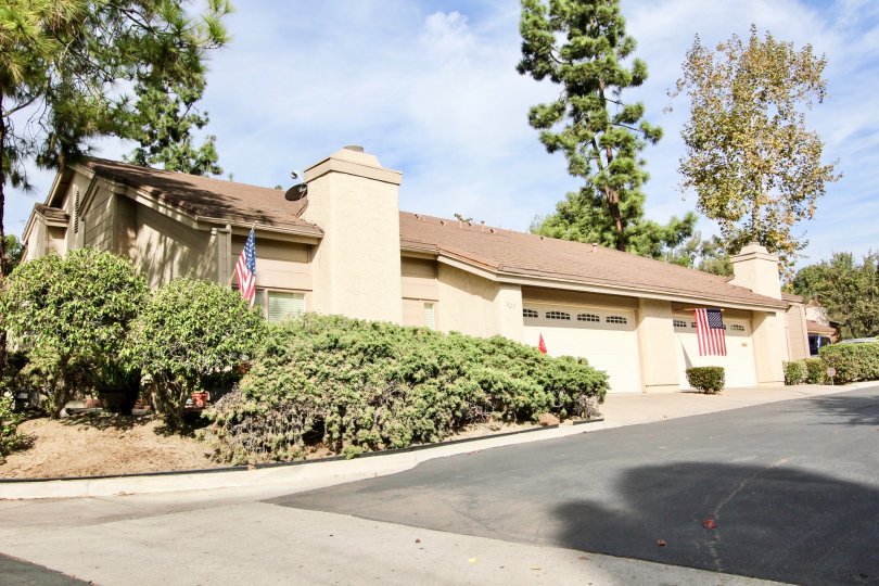 Garage view with American flags and bushes at Windsor View in Chula Vista, California