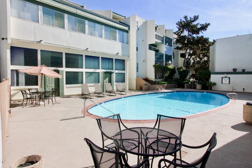 THE APARTMENT IN THE BAY HO WITH THE SWIMMING POO, TABLES, UMBRELLA, PLANTS, TREES
