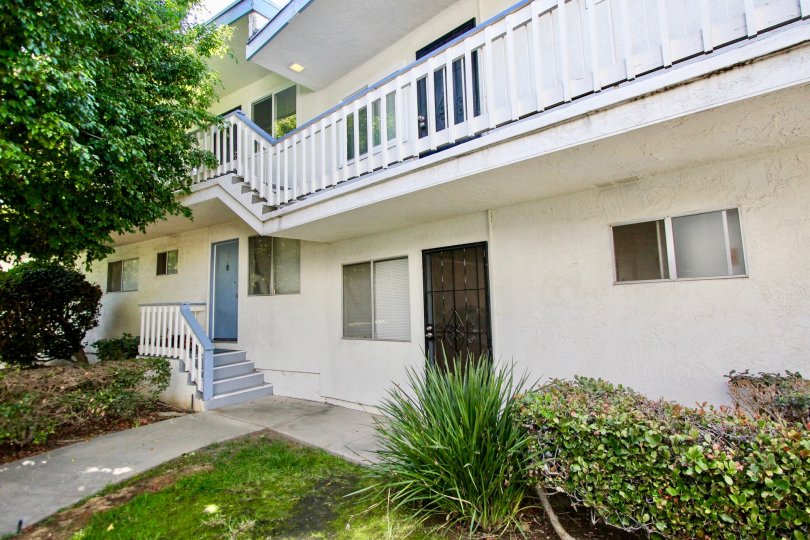 A two story white building with blue details and a 2nd store balcony at Bayview Terrace in Clairemont Mesa, California.