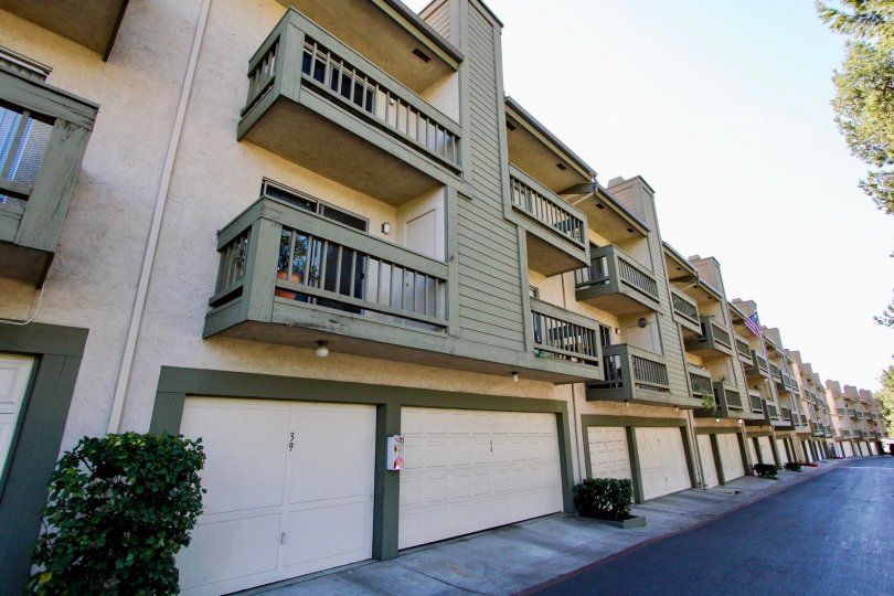 A long black driveway lined with housing & garages inside College Park Townhomes in College Area CA