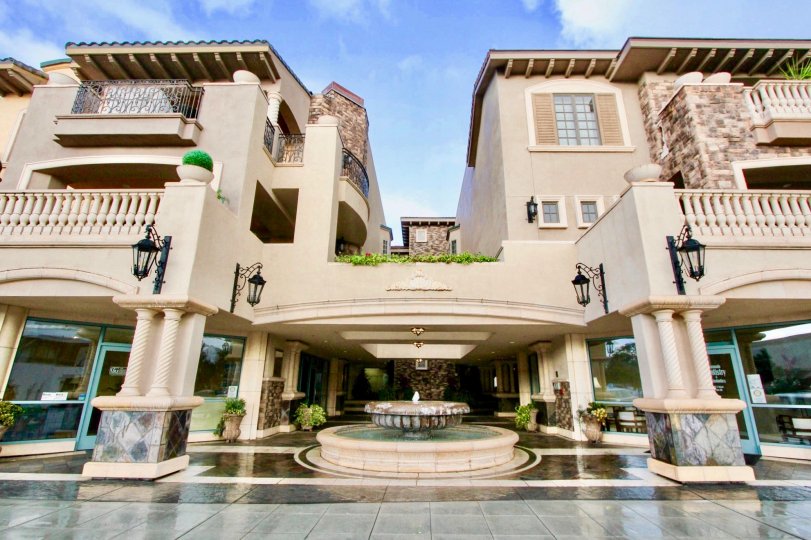 A luxurious apartment building with a fountain during a sunny day in Regatta Bay, Coronado, CA