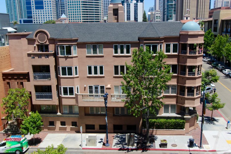 A sunny and warm day at The Columbia Palace with an exterior view of the building with its refresingly interesting and unique architecture and the streets, the trees and parked cars