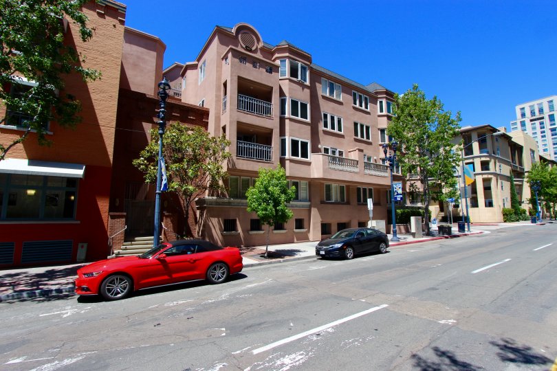 Cars parked outside of pink town homes in Columbia Place in Downtown San Diego CA