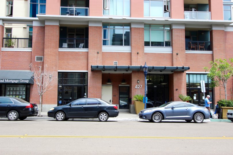 Cars parked below a tall red brick building at Diamond Terrace in Downtown San Diego CA