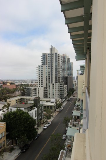 Balcony Street view of the Discovery Condos Downtown San Diego California with parked cars by sidewalks