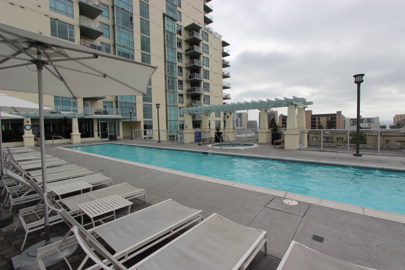 A long, thin pool sits under a dark cloudy sky at Discovery condos