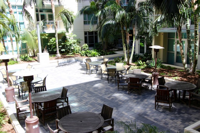 Outside dining area next to palm trees & plants at Discovery in Downtown San Diego CA