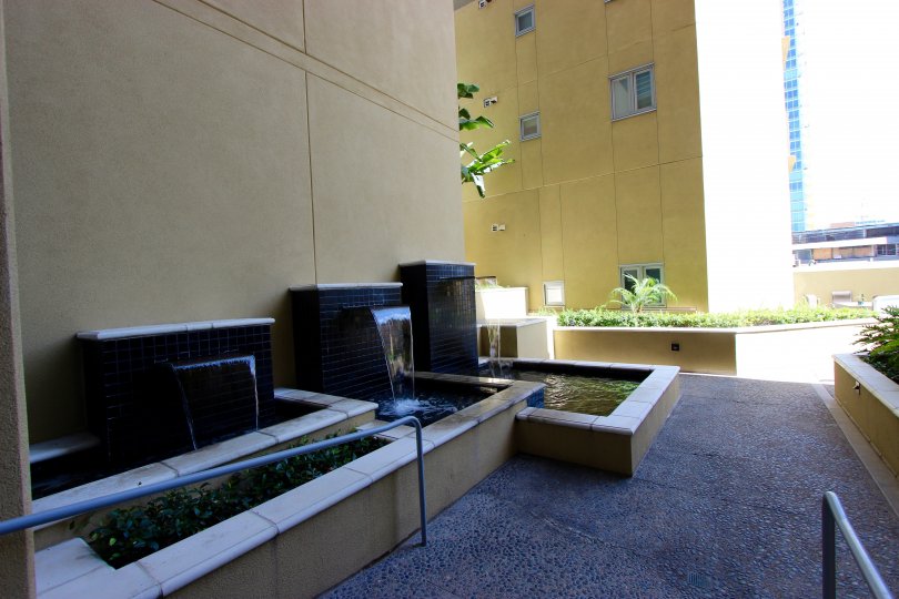 A sunny and bright day at The Element with an exterior view of the therapeutic and refreshing waterfall features and the lush greenery and calm surroundings