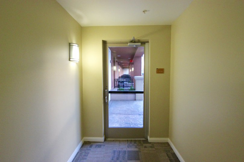 A single wall sconces lights a hallway in the daytime at Gaslamp City Square