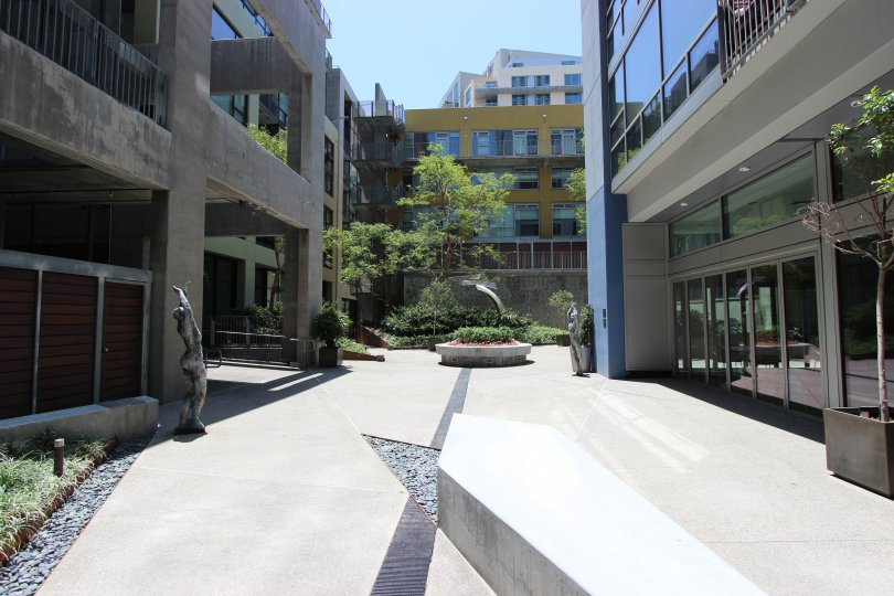 Cloudless sky overlooking courtyard with statues of women.