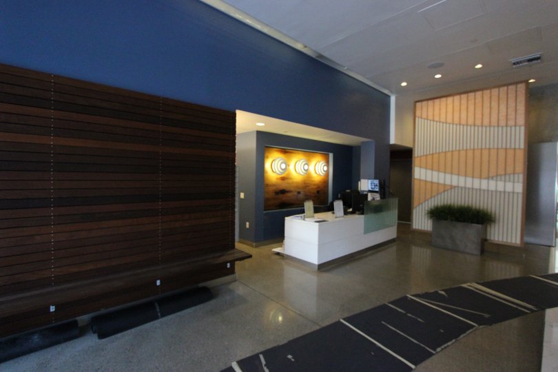A sunny day in the area of Icon, inside, lobby, bench, lights, desk, plants