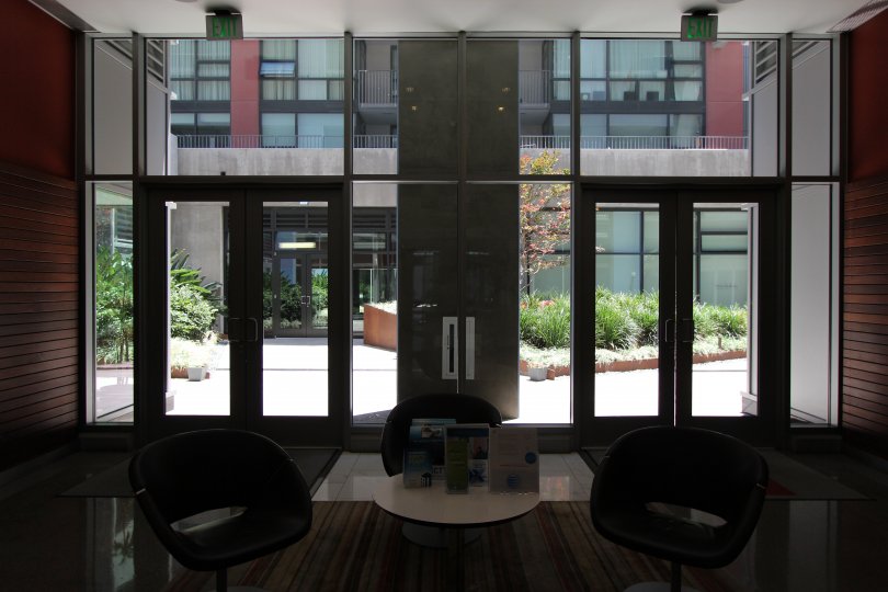 Three chairs sit in the middle of a lobby at the Icon condos