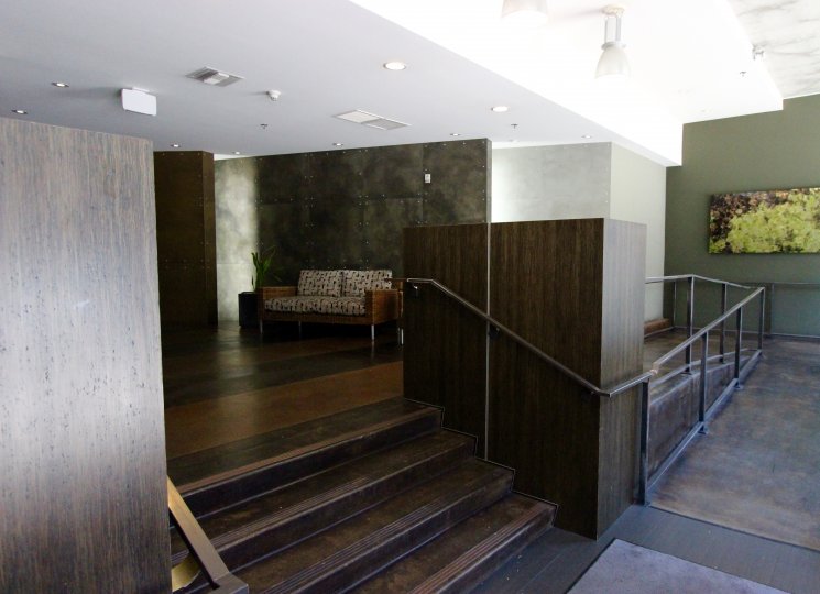 A sunny day in the area of M2i, inside, lobby, stairs, couch, painting, lights