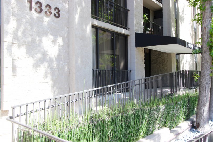 Gray iron fence lined with plants in front of Symphony Terrace at Downtown San Diego CA