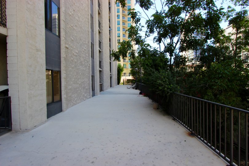 A long, shaded walkway sits next to a gate at the Symphony Terrace condos