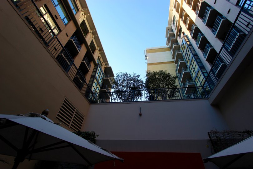 The view upward from a courtyard with umbrellas at Trellis in downtown San Diego, CA