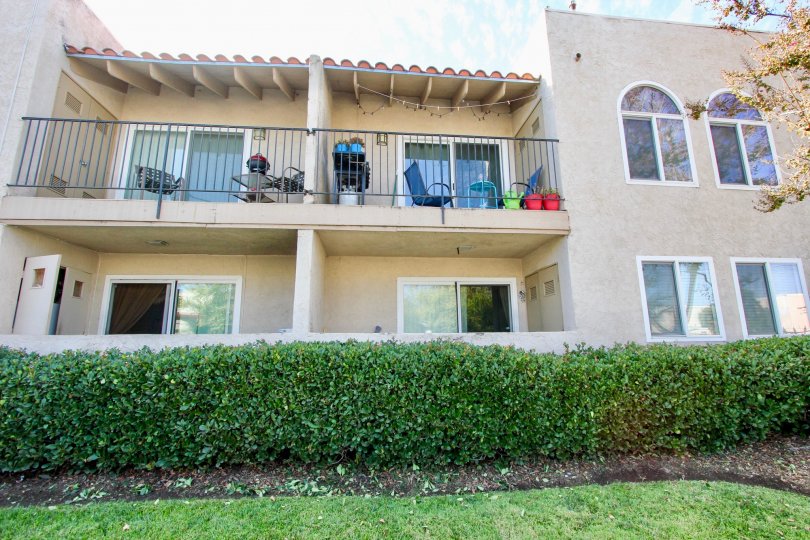 A view of the balcony of several apartments of the Monterra Community in El Cajon, CA on a sunny day surrounded by bushes.