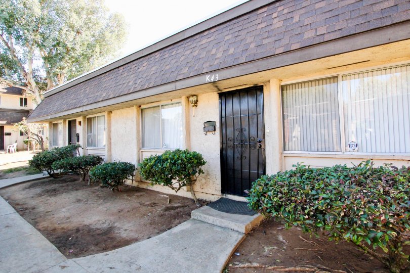One story yellow house with sidewalk and shingled roof, in Villa Grande, Escondido, California.