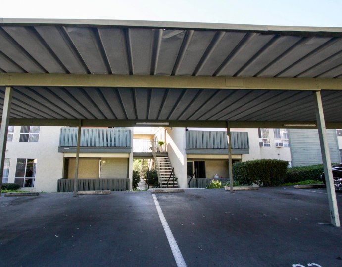 An empty car park is submerged in shade at Village Green condos