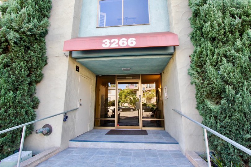 the The Capistrano front entrance with, amu green plants around on both sides of entrance