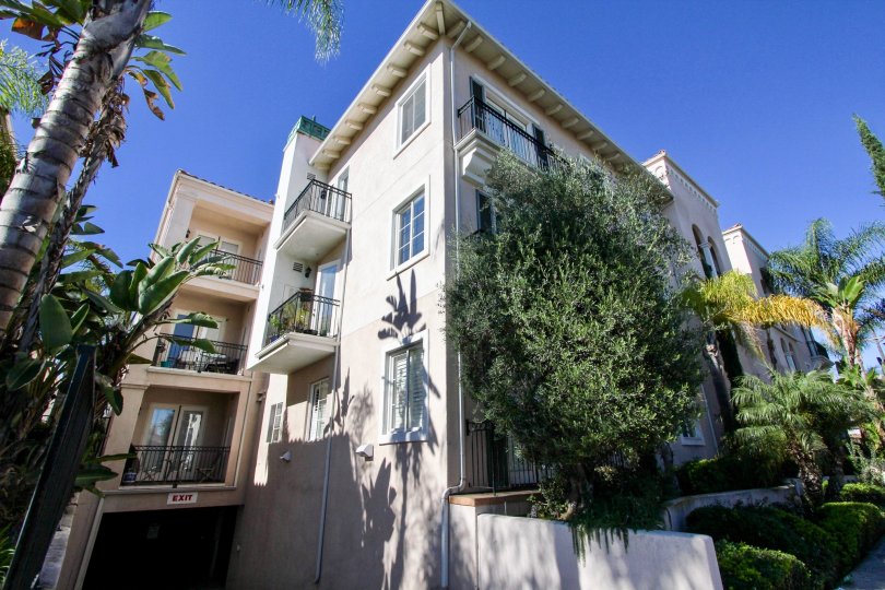 Ample of sunshine with palm trees in front of a multi story villa in Villa Portofino of Hillcrest