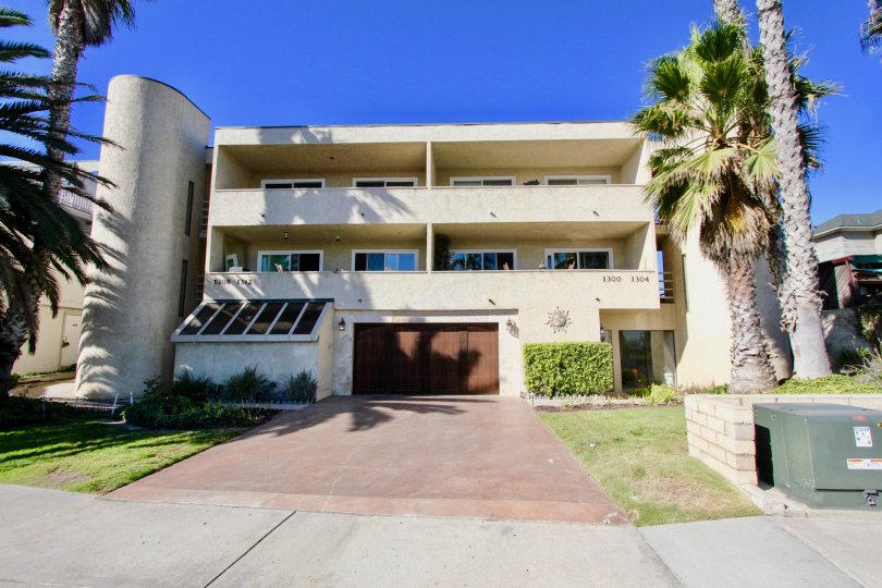 Three story garage with brown garage door and pink driveway at Peerless Shores in Imperial Beach CA