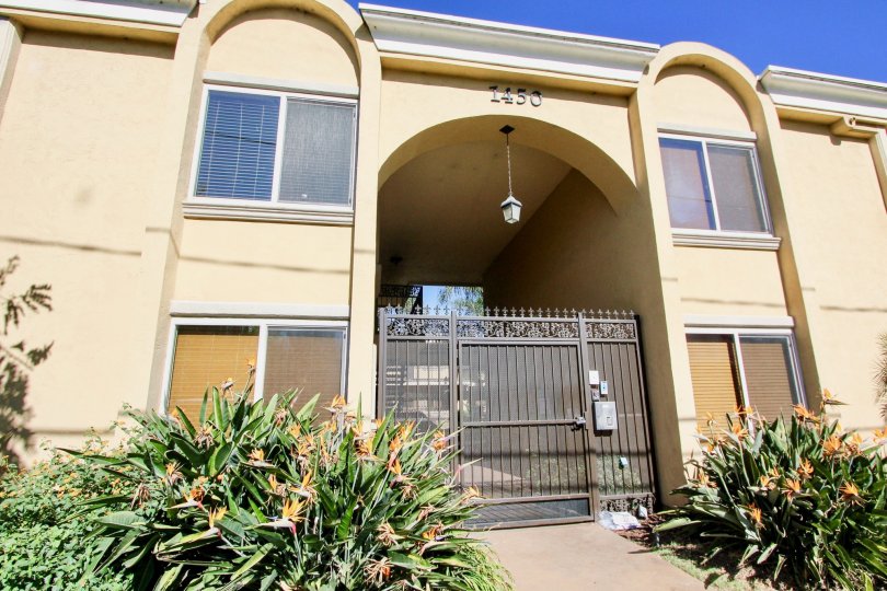 A sunny day in Tapestry has villa with number 1450 in a front view and bushes