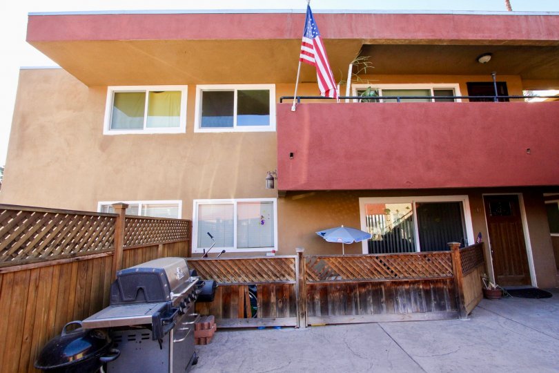 A two story building with a porch, an american flag and an umbrella in Willow Bay