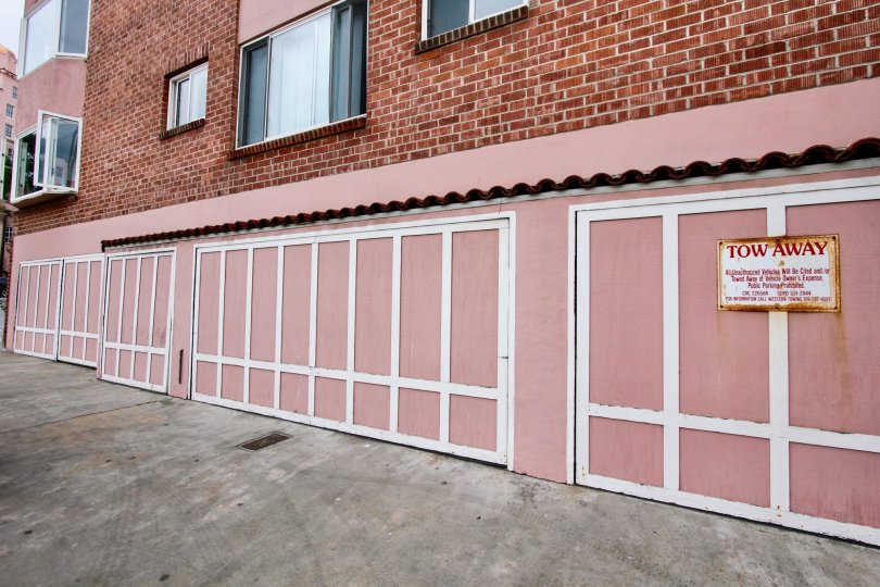 The back of a brick building in Girard Condos with some windows and garages