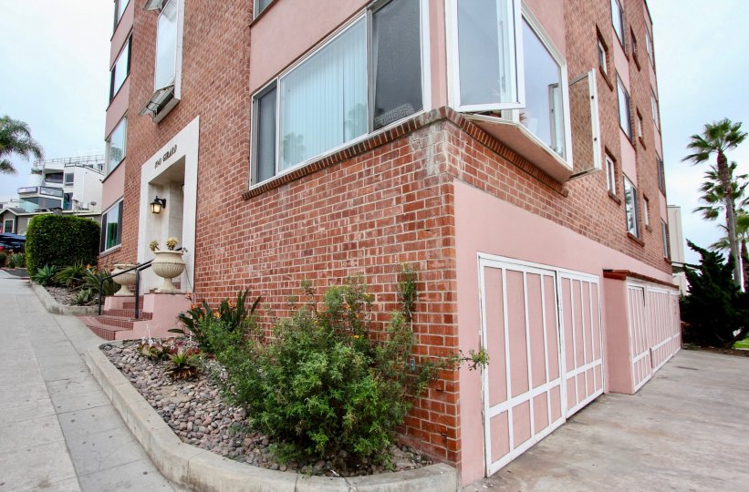Pink brick building with attached garages at 8040 Girard Condos in La Jolla CA