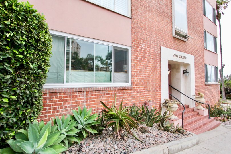 In 8040 Girard Condos, Plants and grasses are cover along the two sides of the entrance