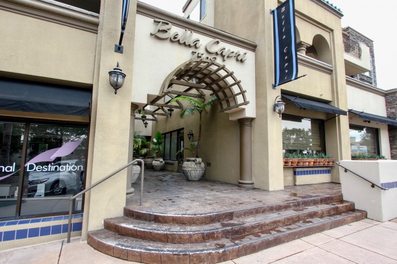 At the entrance of Bella Capri has light lamps, flower pots on the window glass and pot along the entrance