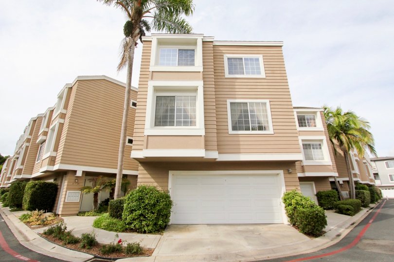 Two story brown building with white garage door inside Cape La Jolla at La Jolla California