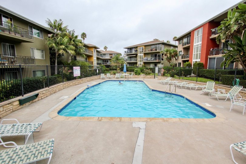 Pool surrounded by condos and furniture at Capri Aire in La Jolla CA