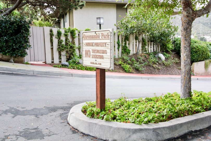 Community sign on planter near tree at Coromandel Park in La Jolla California