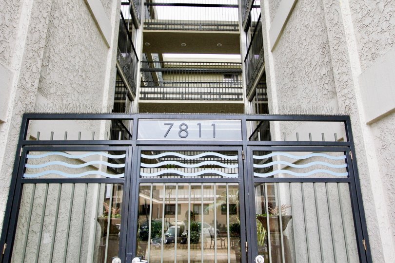 A gate with the street number and a view of the apartments in the back at Devonshire, La Jolla, CA
