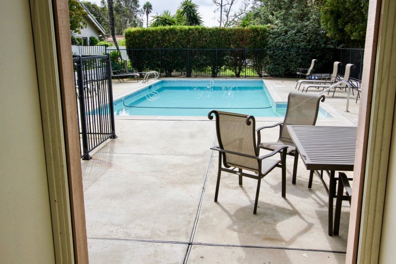 Swimming pool and dining table are at the La Jolla Woods community placed in the state CA