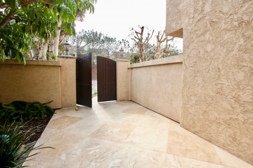 Brown wooden gateway leading to entrance of Sandpiper in La Jolla CA
