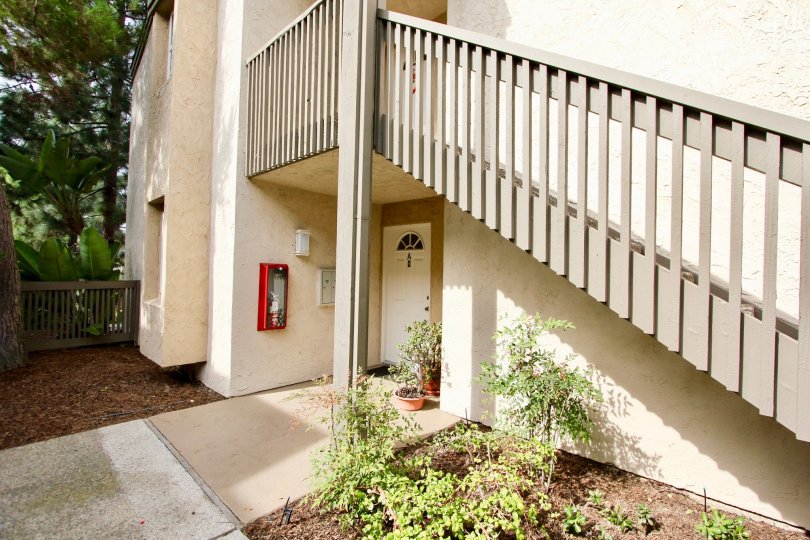 An entrance of a building in the Villa La Jolla with beautiful plants.
