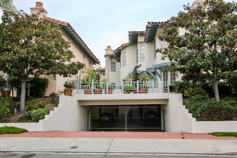 A street view of the Villas of Ivanhoe that displays the parking garage and garden in La Jolla, California.